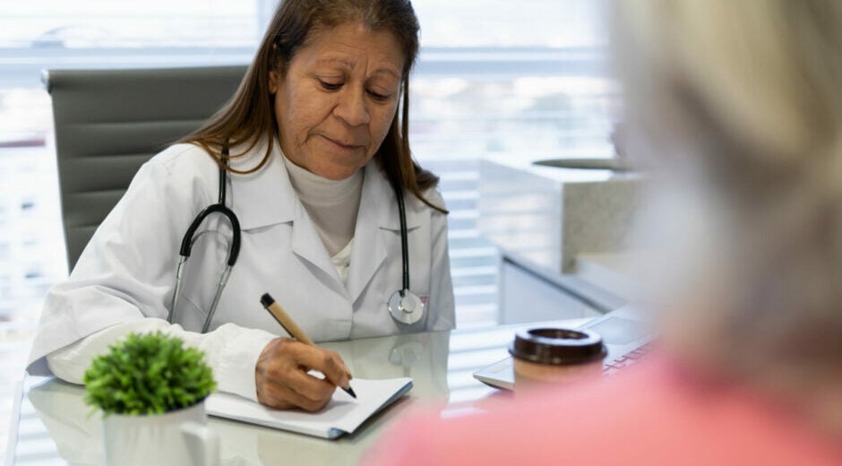 Commentary 3 QME physician with pen taking notes during medical appointment in doctors office health, medicalcare, care concept..